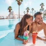 Young couple on infinity pool cocktails From Classic to Creative: Inspiring Honeymoon Ideas for Newlyweds