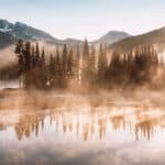 South Sister and Broken Top reflect over the calm waters of Spar 12 Most Panoramic Train Rides Across the U.S.