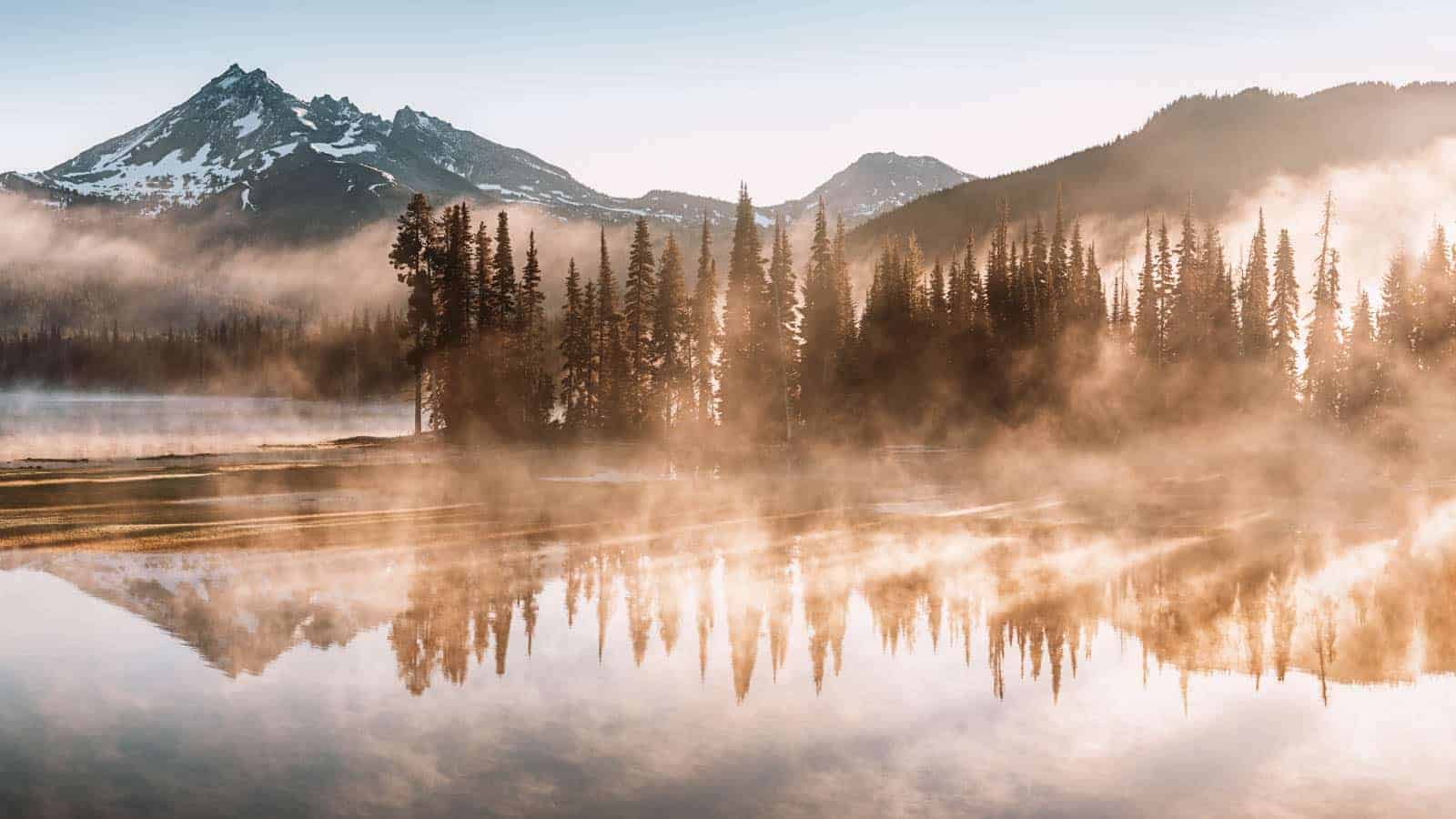South Sister and Broken Top reflect over the calm waters of Spar 12 Most Panoramic Train Rides Across the U.S.