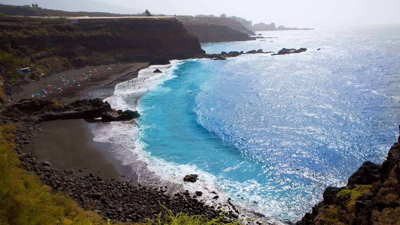 Beach el Bollullo black brown sand and aqua water 12 Hidden Beaches in Europe to Avoid the Crowds